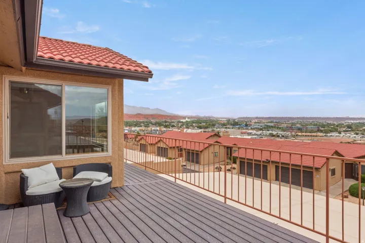 Expansive elevated deck with composite decking, metal railing, and a tile roof overhang