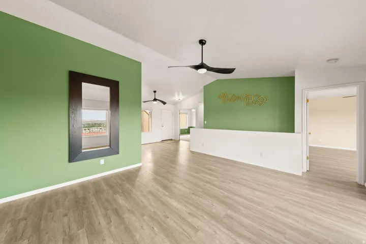 Vaulted ceilings, wood-finish flooring, and modern ceiling fans