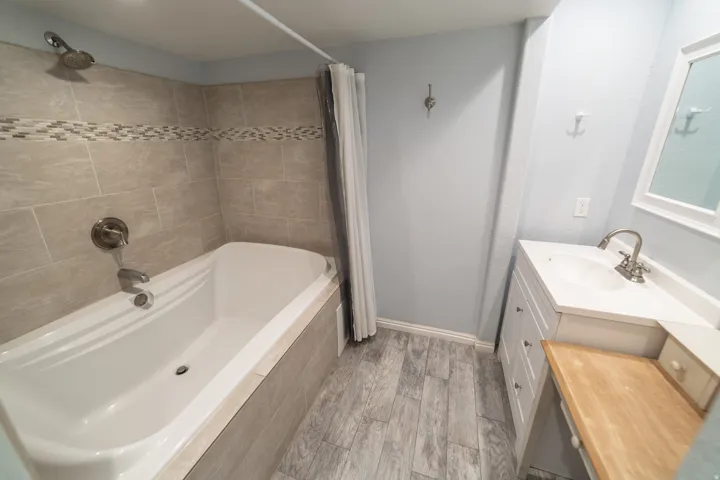 Built-in bathtub with subway tile surround and decorative mosaic accent