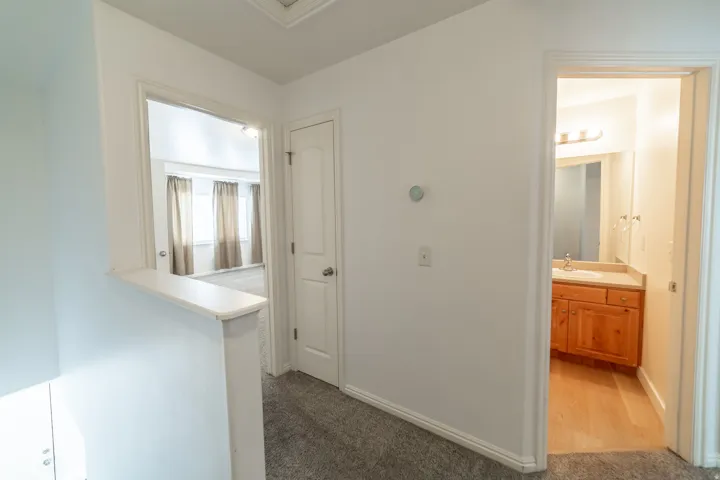 Carpeted hallway with white walls and trim