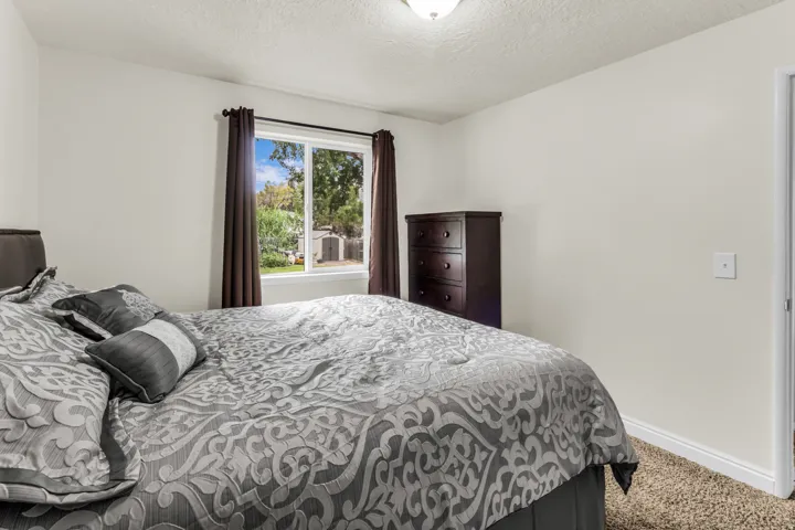 Carpeted flooring, white walls, and a window with outdoor scenery