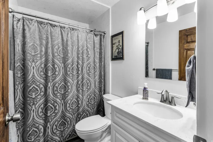 Bathroom featuring a vanity with an integrated sink, a brushed nickel faucet, and overhead vanity lighting