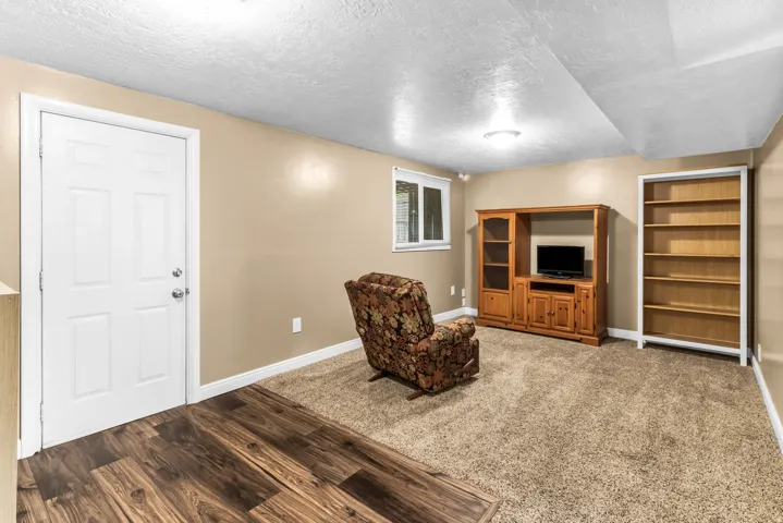 Wood-finish flooring, neutral carpeting, window with white trim, and recessed lighting