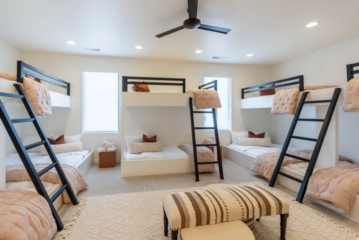 Built-in bunk beds with integrated ladders, recessed lighting, ceiling fan, and carpeted flooring
