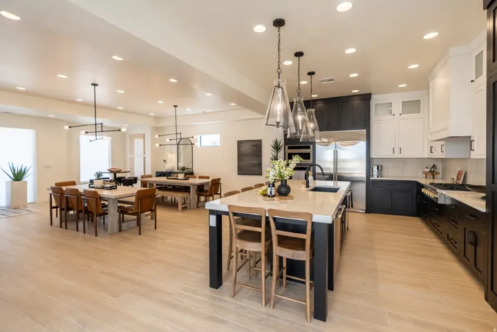 Open-concept main level featuring light wood-finish flooring, recessed lighting, and a kitchen with two-tone cabinetry