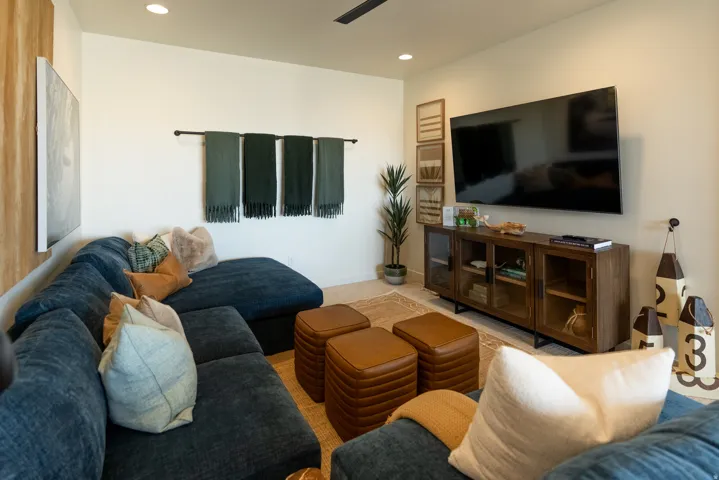 Recessed lighting illuminates neutral walls and a ceiling fan