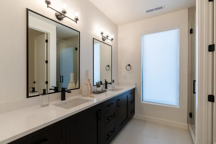 Dual vanity with white countertops and matte black fixtures