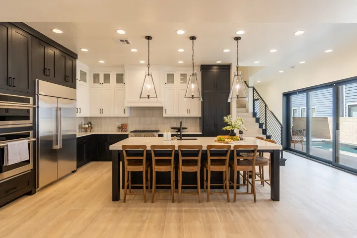 Gourmet kitchen with two-tone cabinetry, integrated stainless steel appliances, and a large island with seating