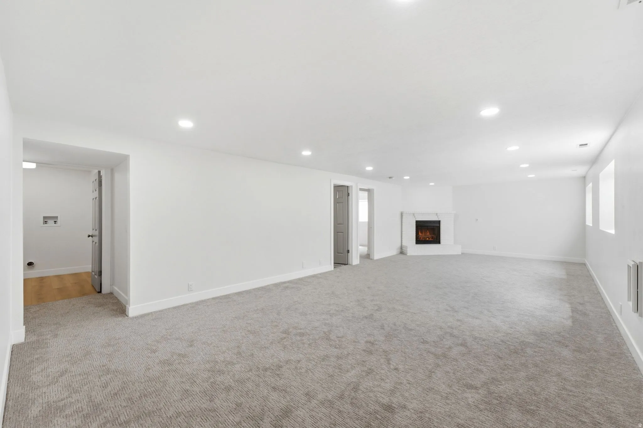 Spacious room featuring light-toned carpeting and recessed lighting