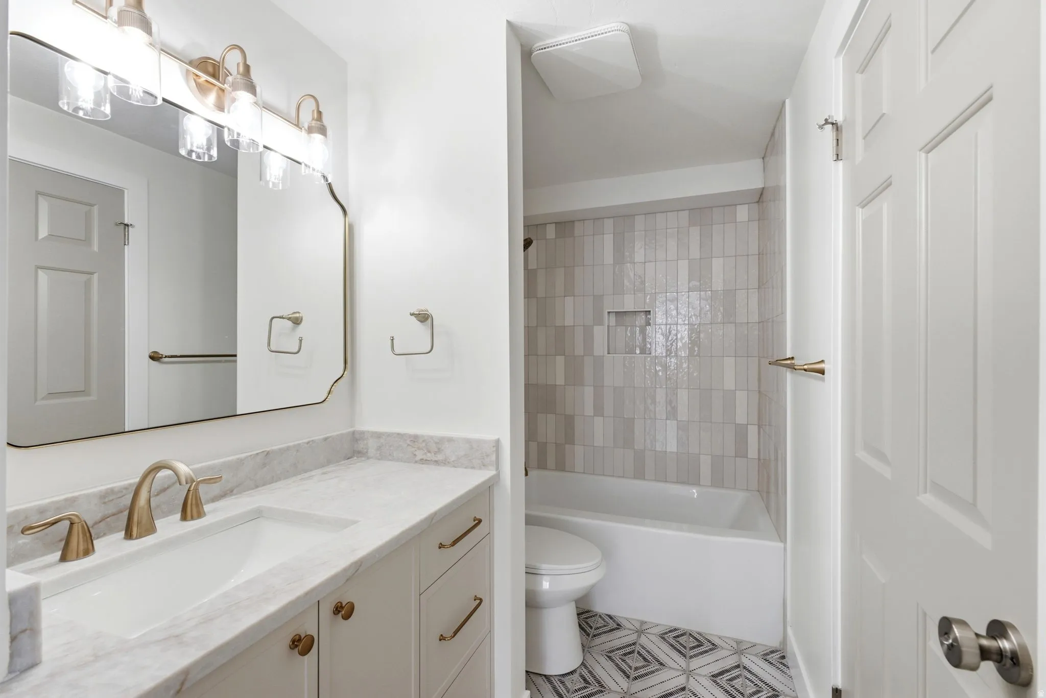 White vanity with a stone countertop and integrated sink