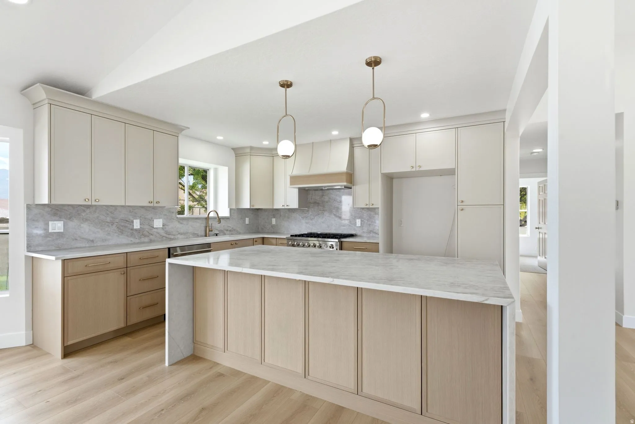Kitchen featuring wood-finish flooring, a central island with countertop, and integrated appliances