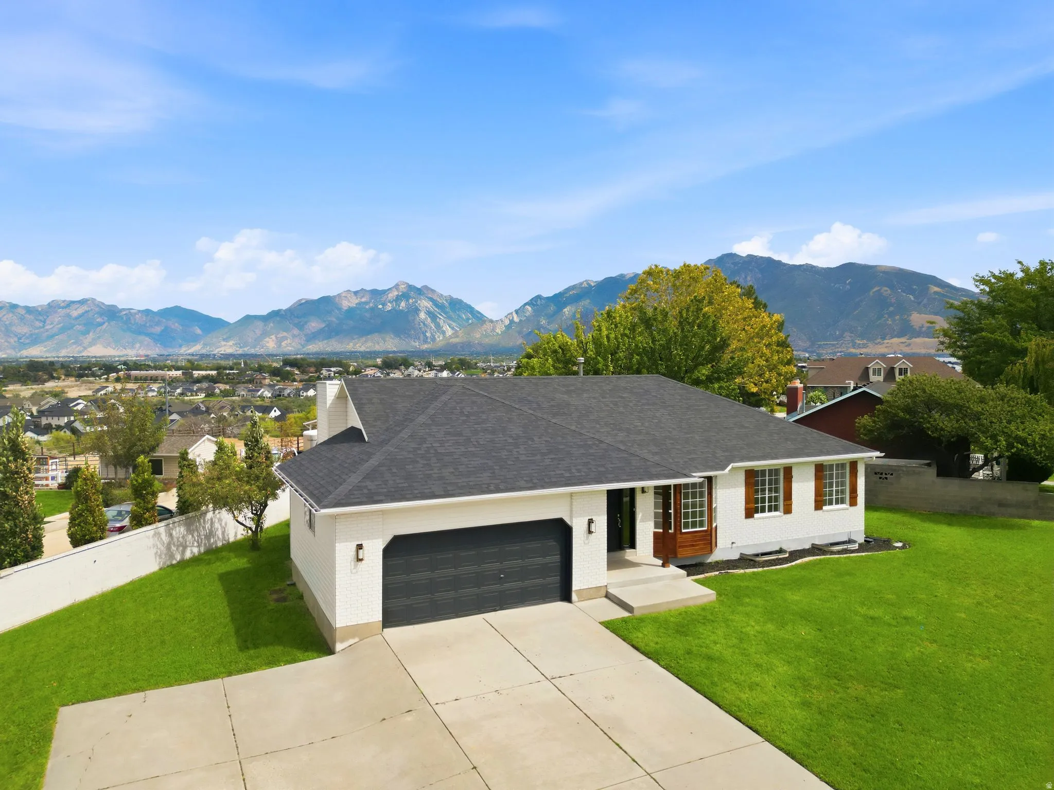 White exterior with dark roof and attached two-car garage