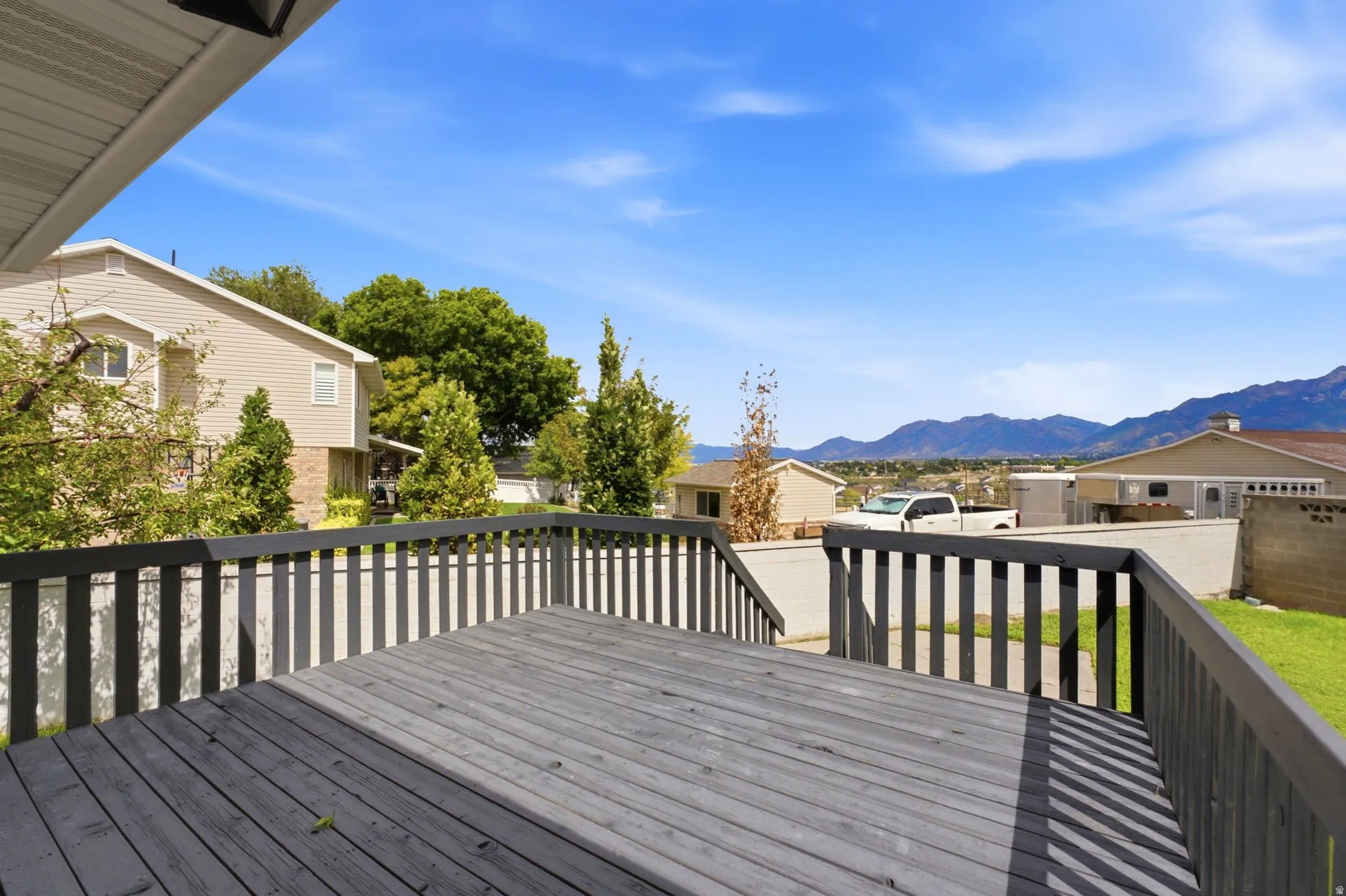 Expansive wooden deck with dark-stained railings and mountain scenery