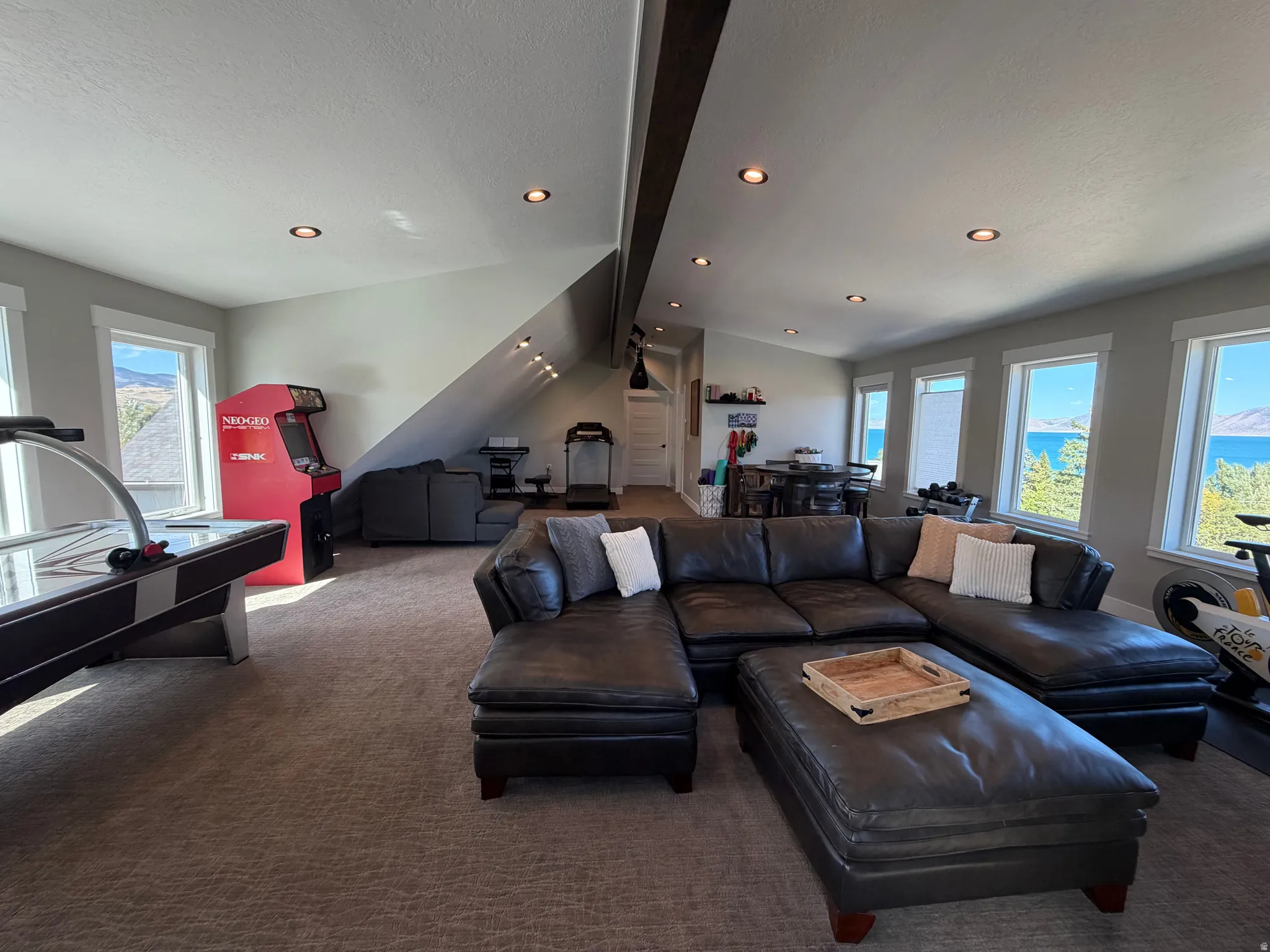 Spacious bonus room featuring multiple windows, recessed lighting, sloped ceilings, and plush carpet flooring