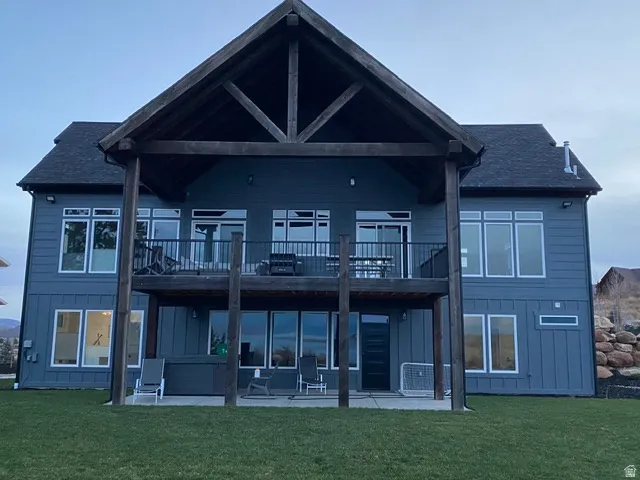Two-story exterior with a covered upper deck, lower patio, and a sloped roofline