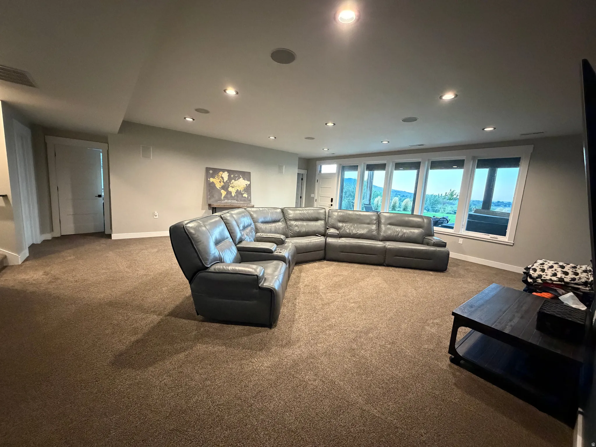 Recessed lighting, light gray walls, brown carpeting, multiple windows, and white trim