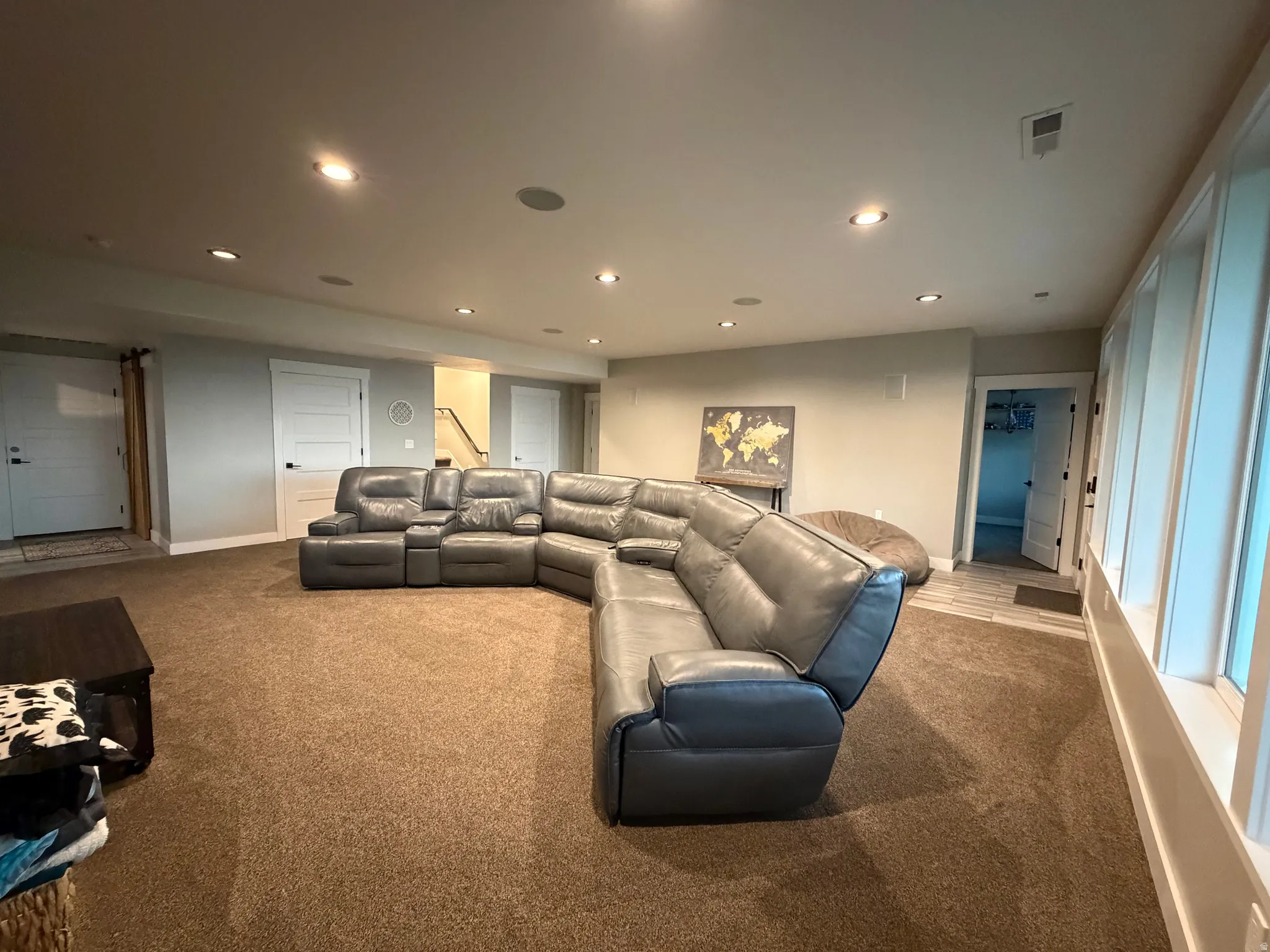 Recessed lighting, light-colored walls, and neutral carpeting