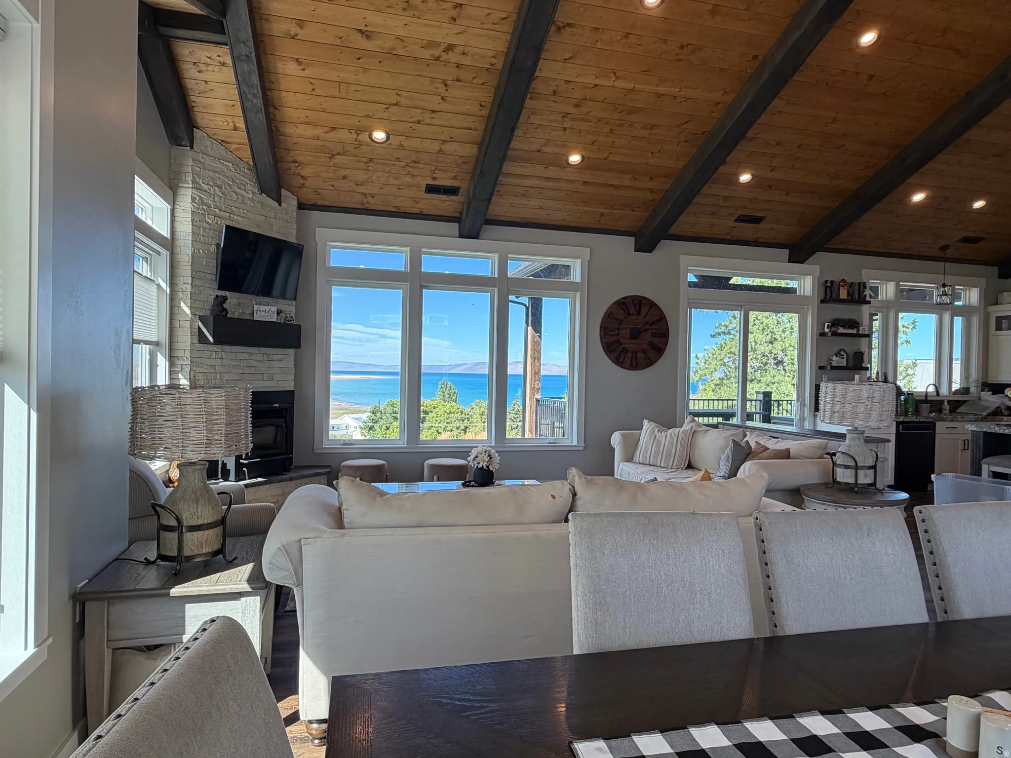 Vaulted wood-plank ceiling with exposed beams, recessed lighting, and multiple windows