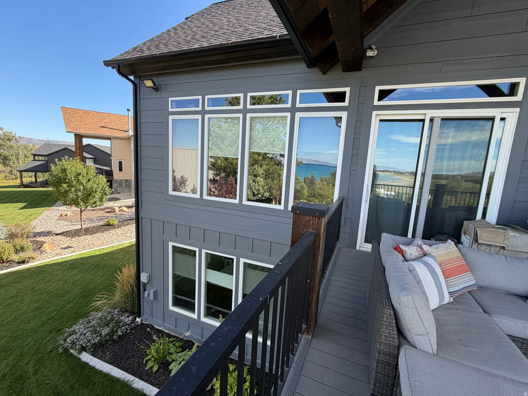 Board-and-batten siding exterior, multiple large windows, sliding glass door, and a low-maintenance composite deck surface