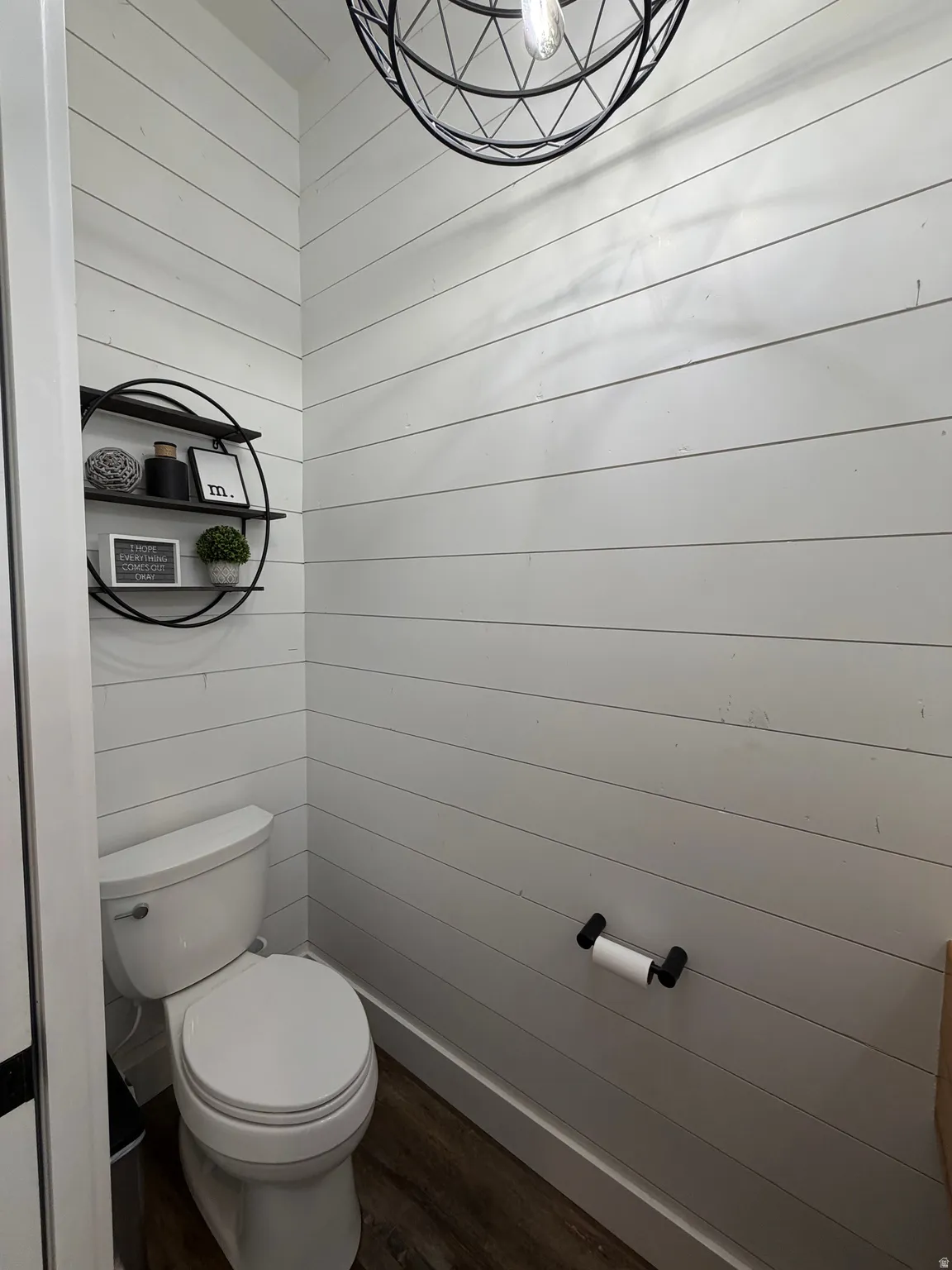 Shiplap wall accents, wood-finish flooring, and a contemporary spherical light fixture