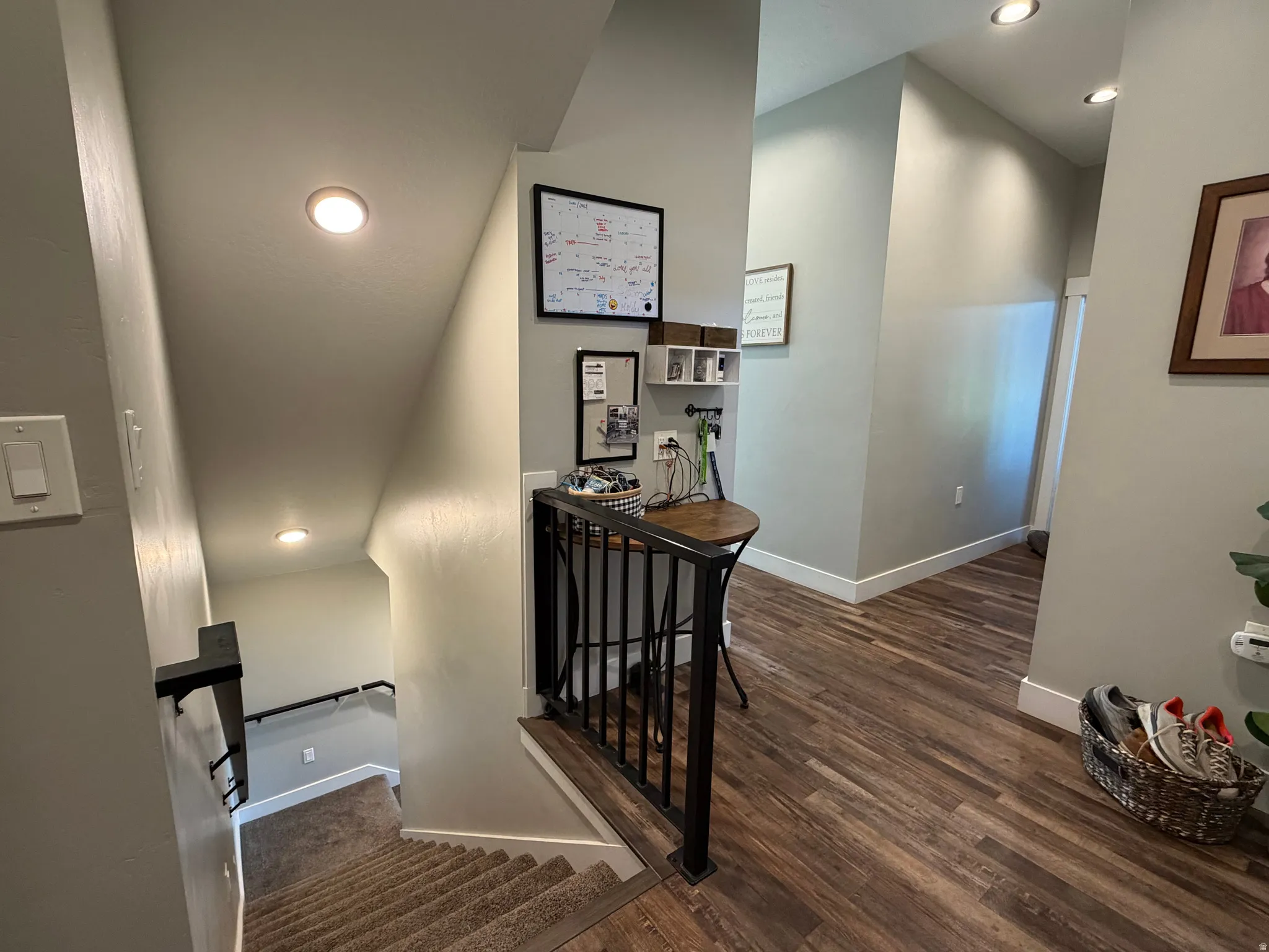 Staircase with carpeted treads, dark metal railing, and recessed lighting