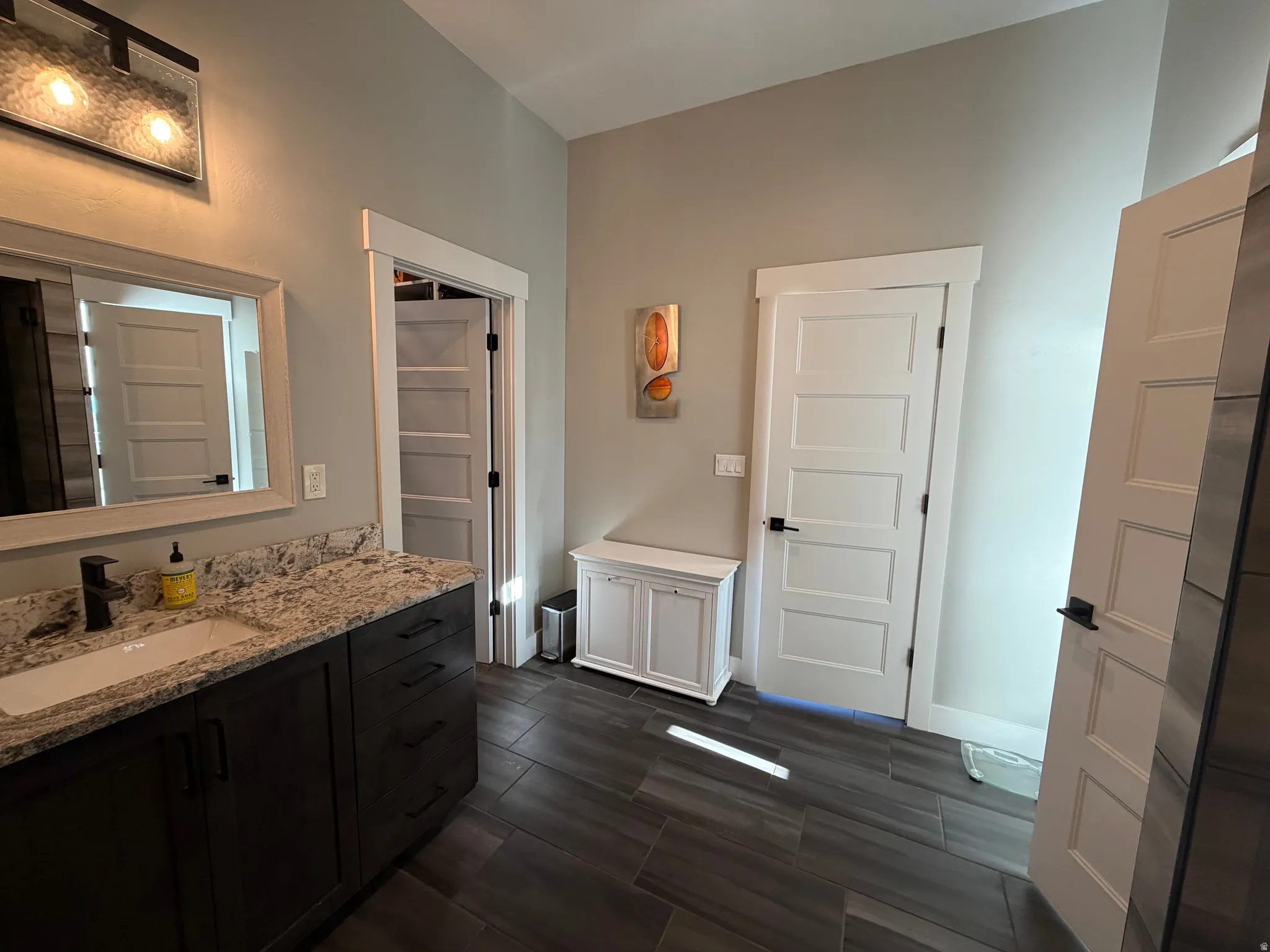 Dark wood-finish vanity with a built-in rectangular sink and stone countertop