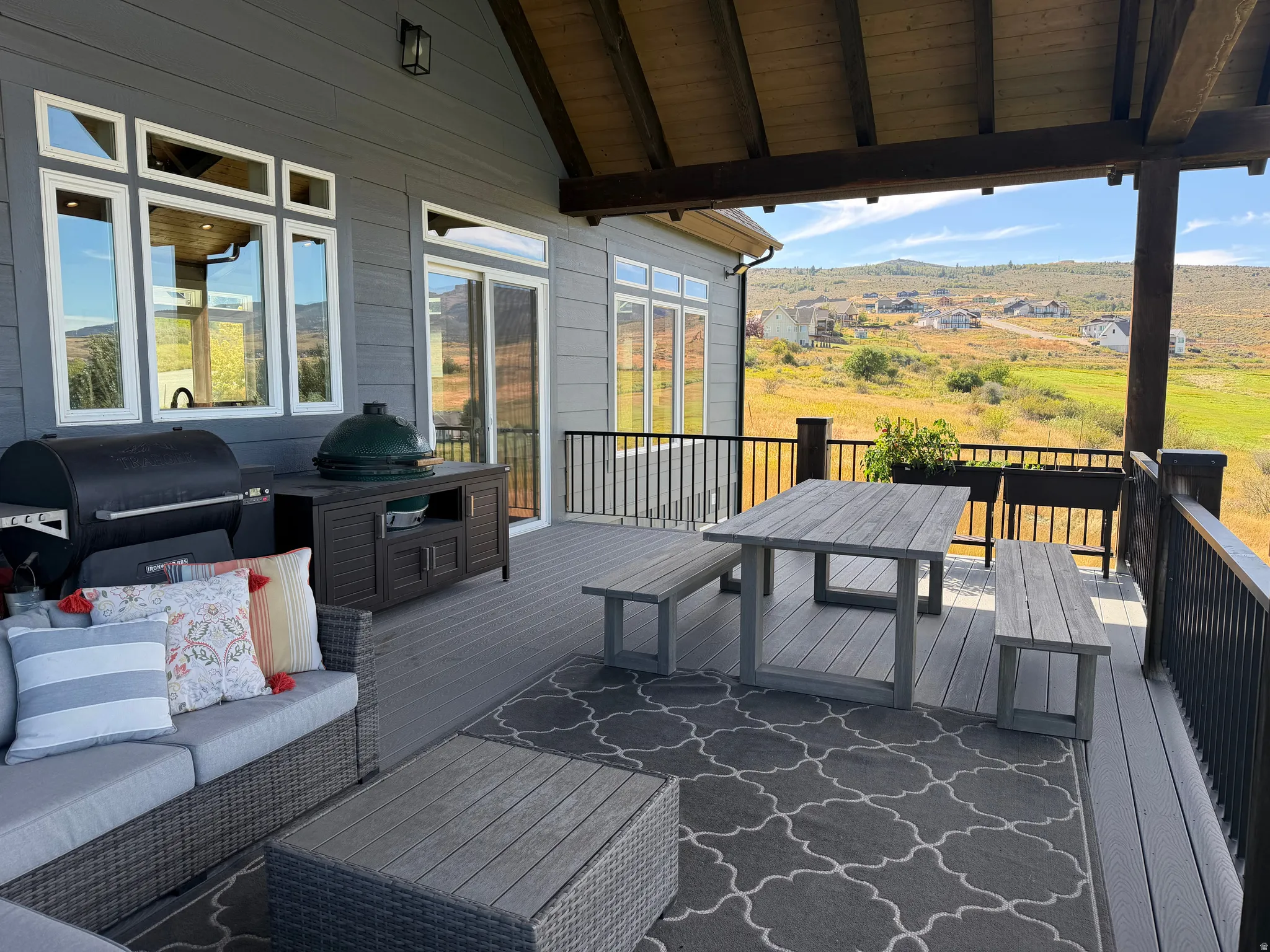 Expansive covered deck featuring composite decking and a black metal railing
