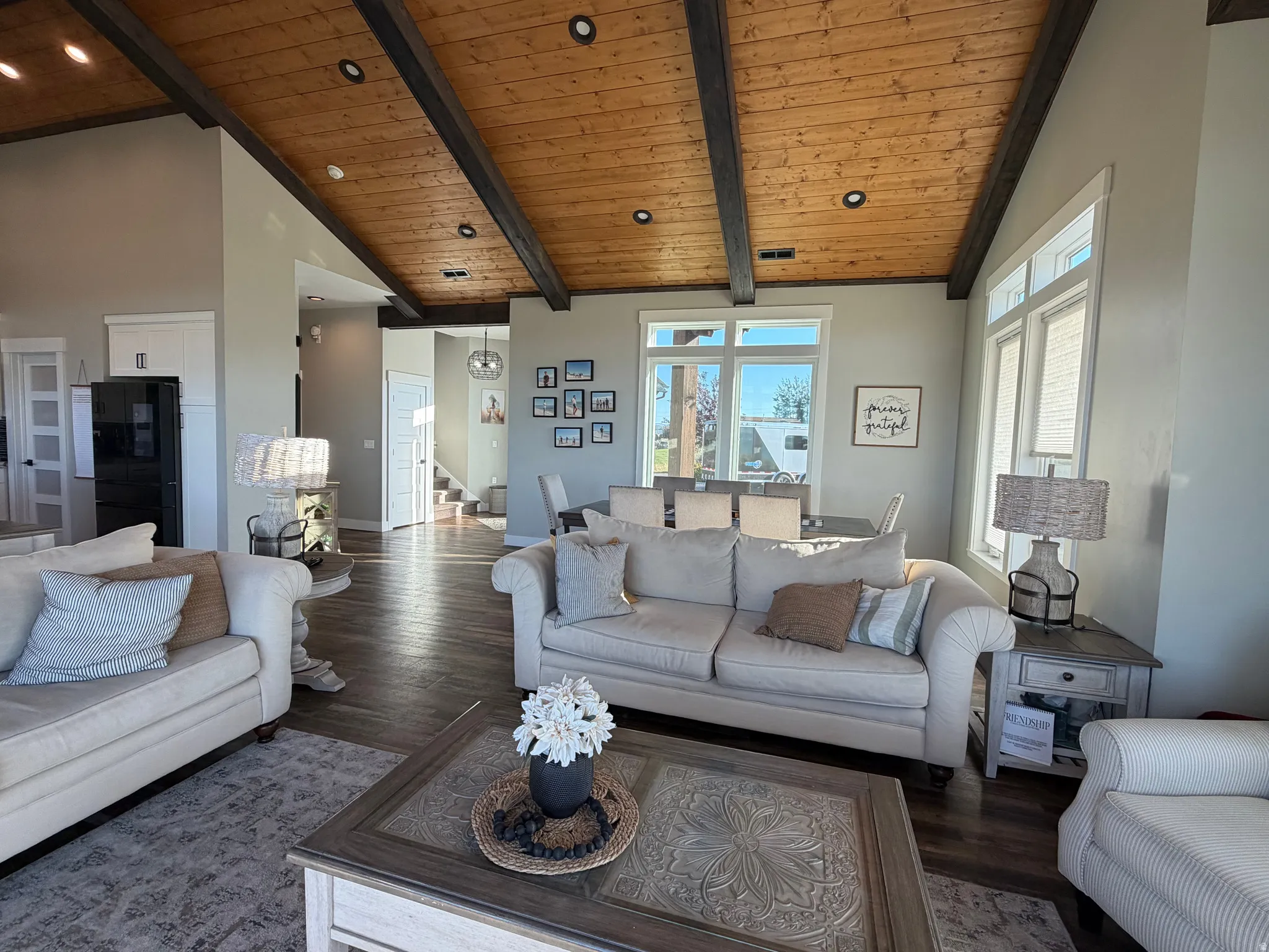 Vaulted wood-paneled ceiling with exposed beams, recessed lighting, and expansive windows