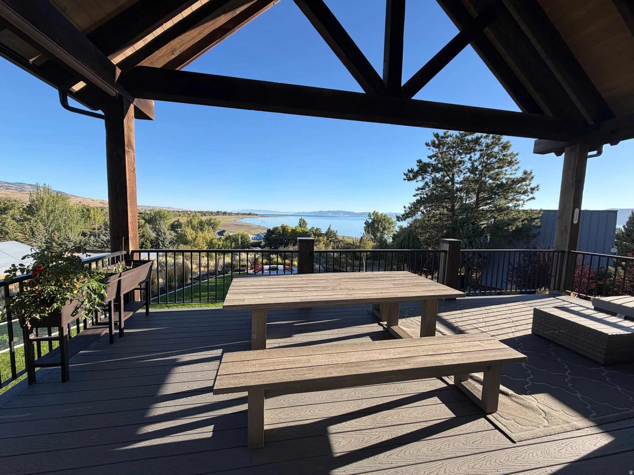 Expansive outdoor deck featuring composite decking, a sturdy wood-beamed pergola, and metal railings
