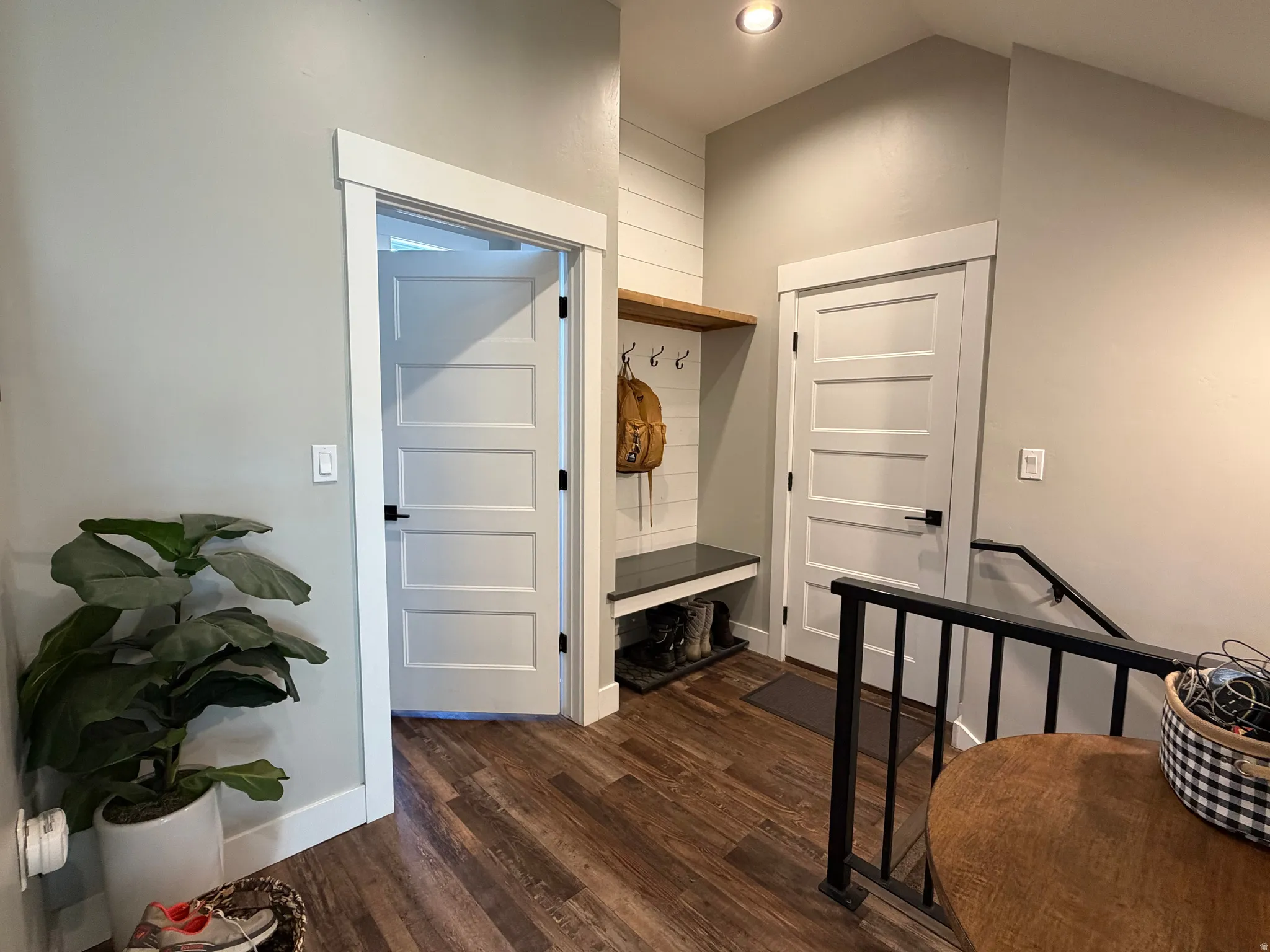 Wood-finish flooring, recessed lighting, built-in shelving with bench, and contemporary interior doors with black hardware