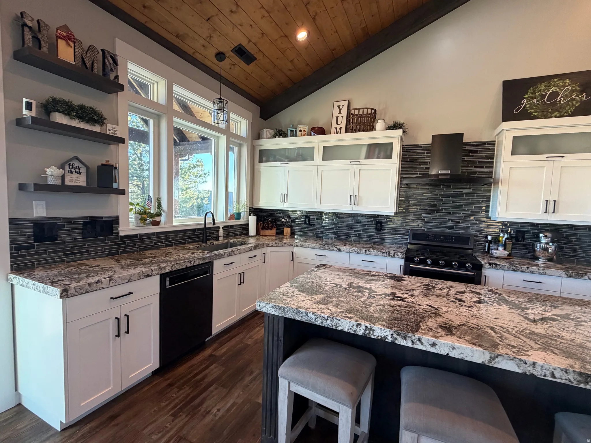 Vaulted wood-finish ceiling, white cabinetry with dark hardware, stone countertops, dark tile backsplash, and wood-finish flooring