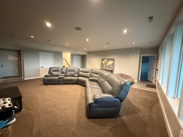 Recessed lighting, light-colored walls, and neutral carpeting