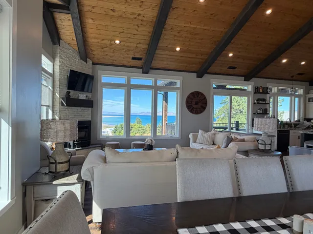 Vaulted wood-plank ceiling with exposed beams, recessed lighting, and multiple windows