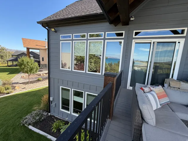 Board-and-batten siding exterior, multiple large windows, sliding glass door, and a low-maintenance composite deck surface