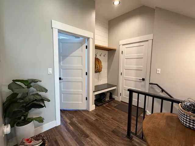 Wood-finish flooring, recessed lighting, built-in shelving with bench, and contemporary interior doors with black hardware