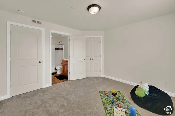 Bedroom 3 with neutral wall color, new carpeting, Jack/Jill bathroom with a wood-finish vanity