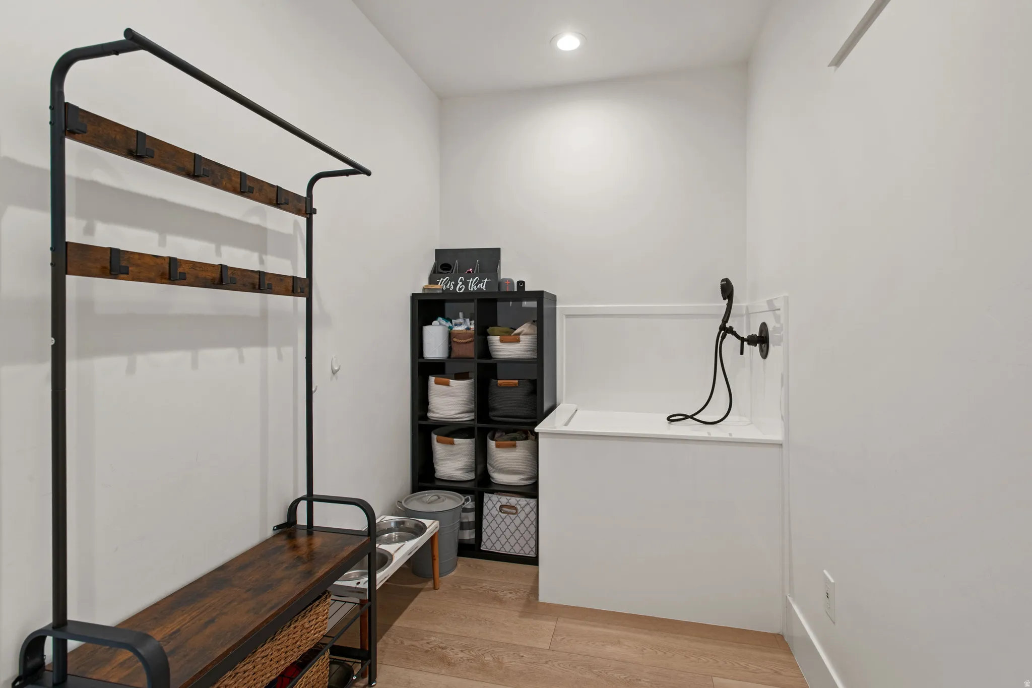 Integrated pet wash station with matte black handheld sprayer and white basin