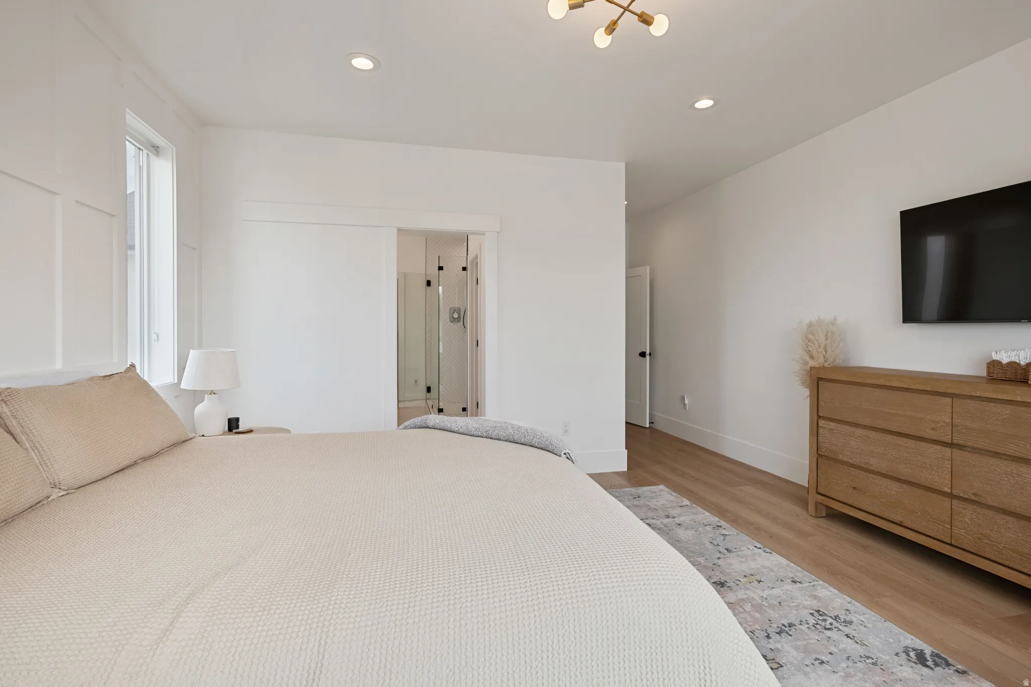 Wood-finish flooring with white walls and recessed lighting