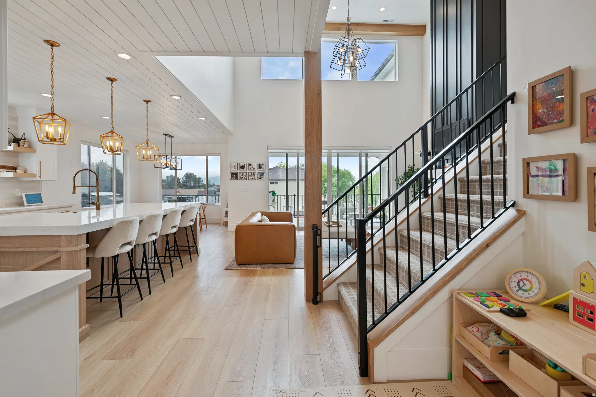 Open-concept living space featuring wood-finish flooring and a kitchen island with seating
