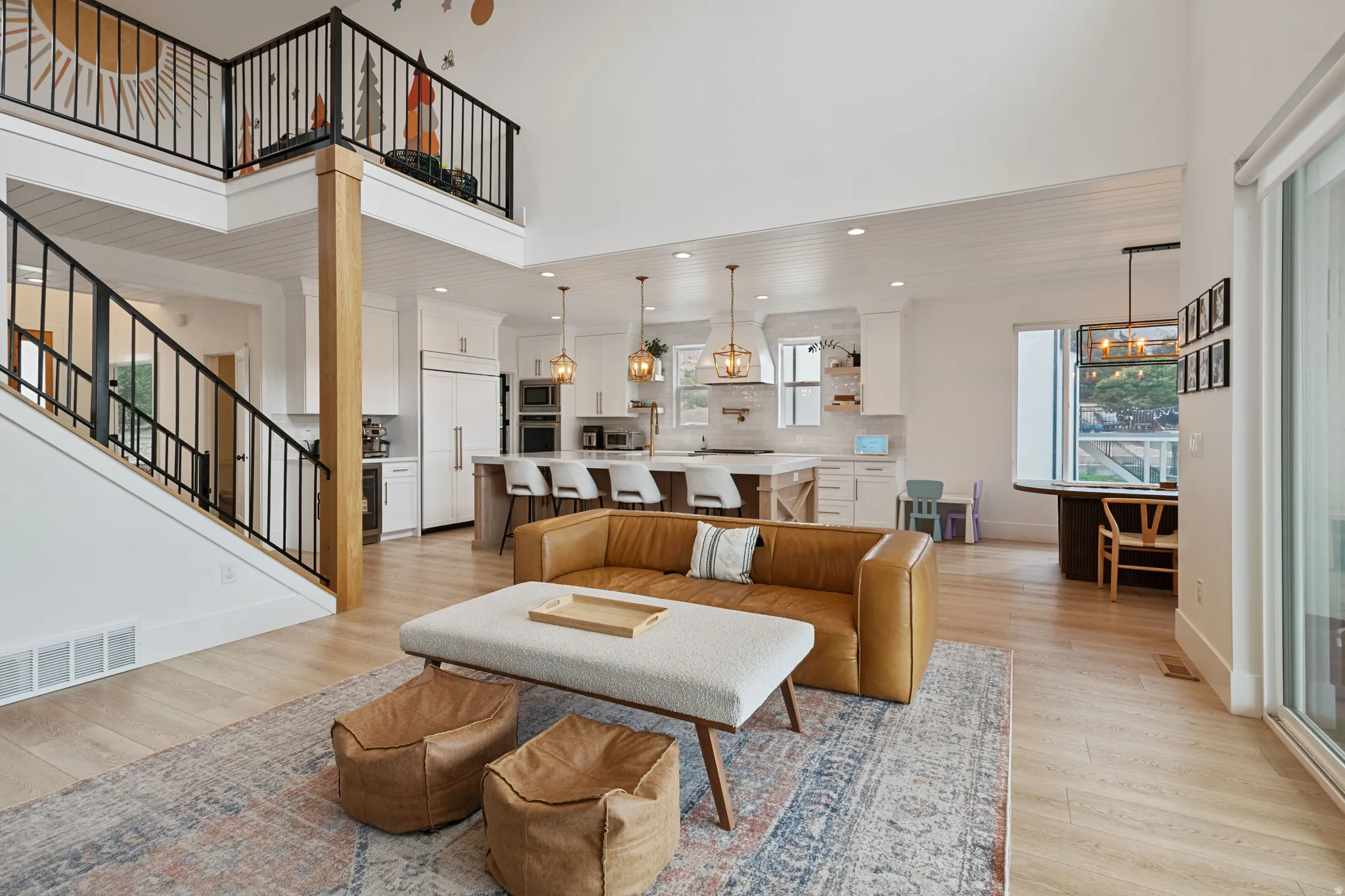 Open-concept main level with wood-finish flooring, a kitchen island, and a built-in kitchen hood
