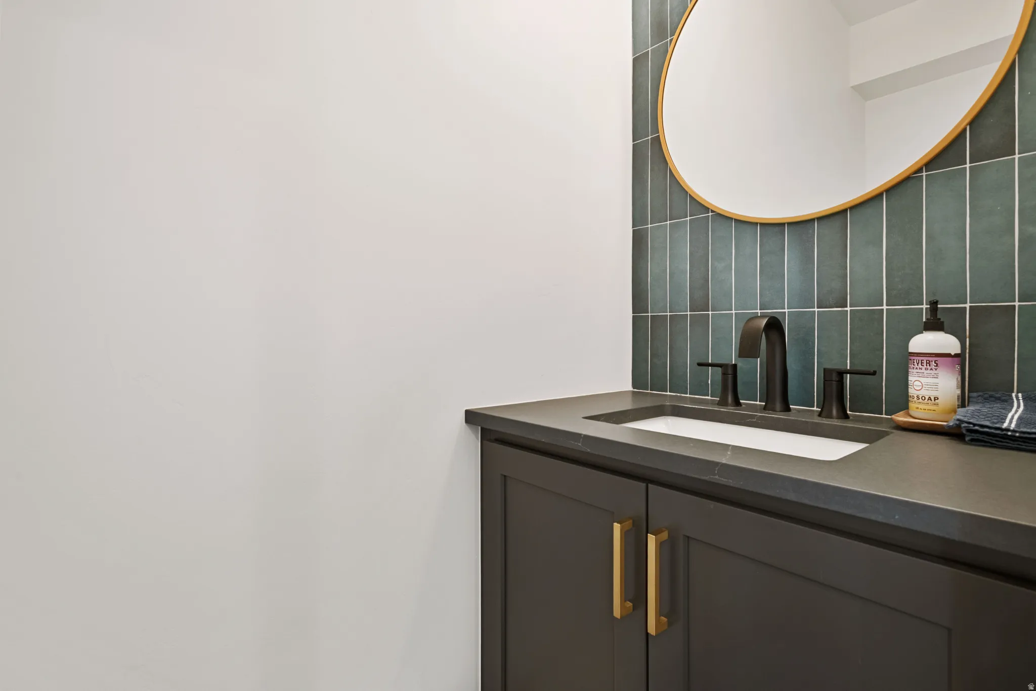 Integrated vanity with a dark countertop and undermount sink