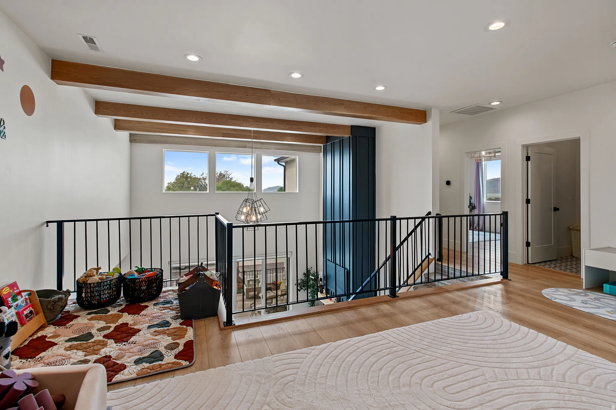 Exposed wood ceiling beams, recessed lighting, and wood-finish flooring