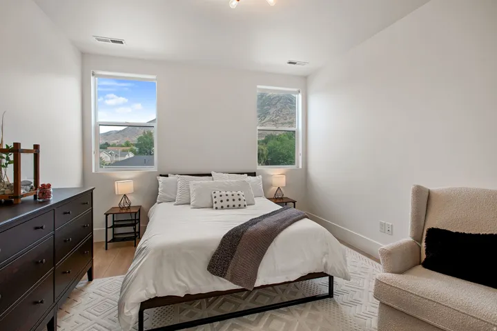 Recessed lighting, wood-finish flooring, two large windows, white walls, and prominent mountain scenery