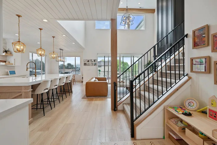 Open-concept living space featuring wood-finish flooring and a kitchen island with seating