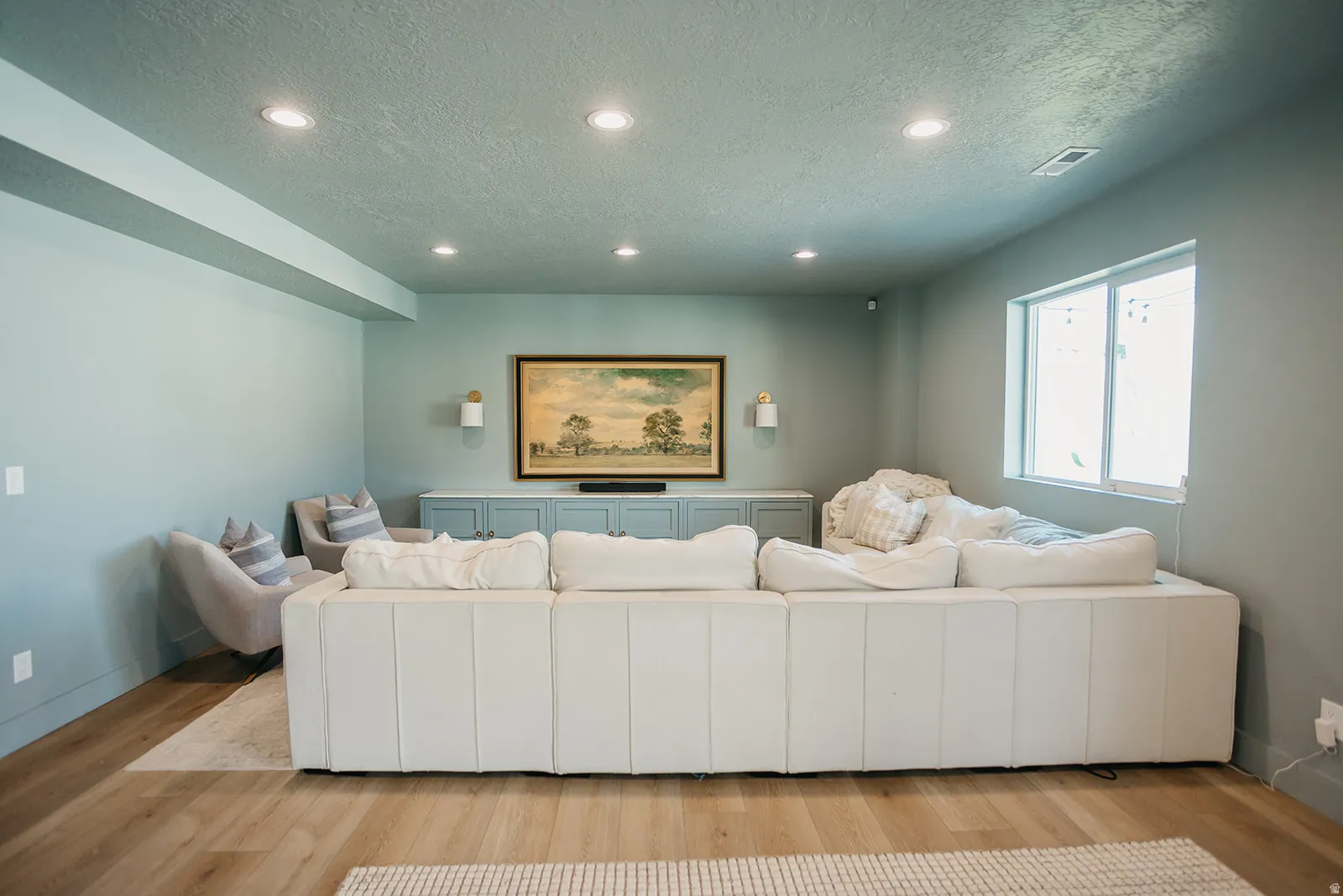 Recessed ceiling lighting, wood-finish flooring, built-in cabinetry, and a prominent window