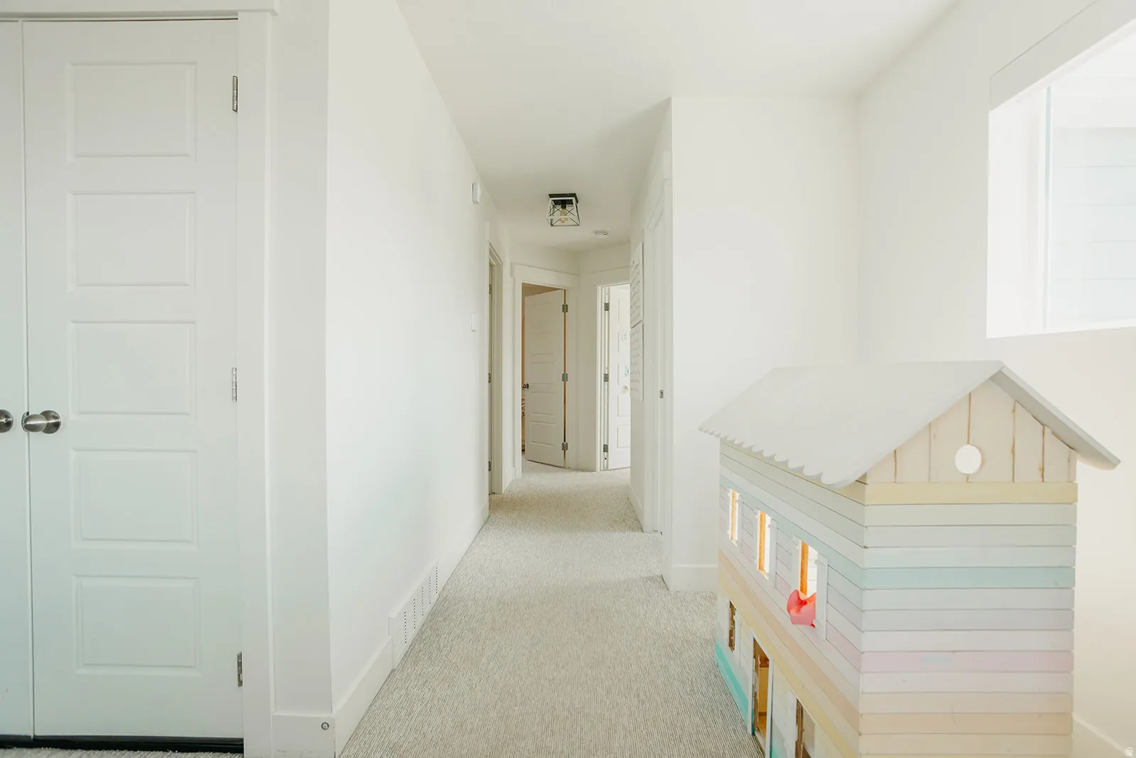 Crisp white walls, light-toned carpeting, recessed lighting, and white paneled doors