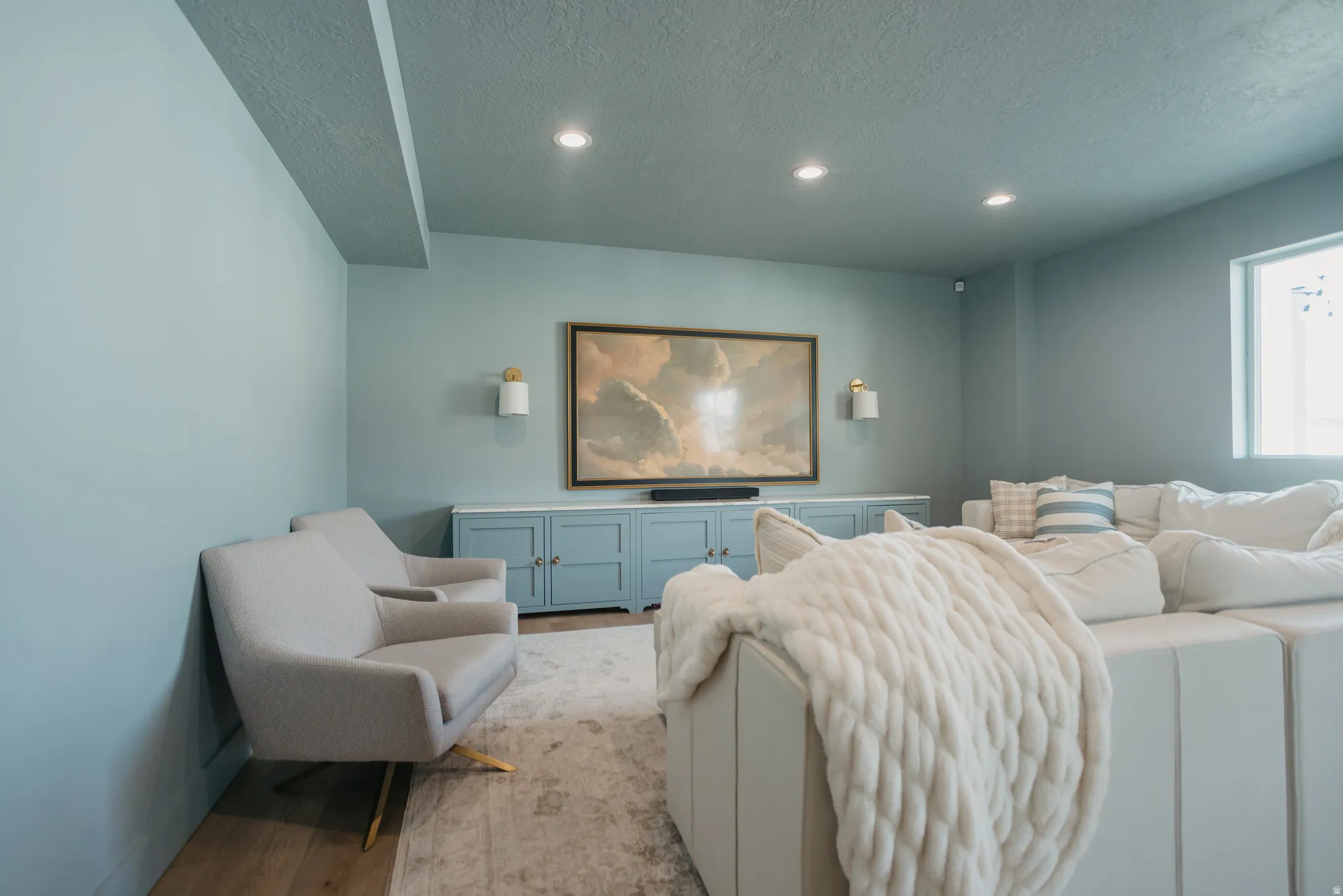 Recessed lighting illuminates a built-in media console with storage cabinetry