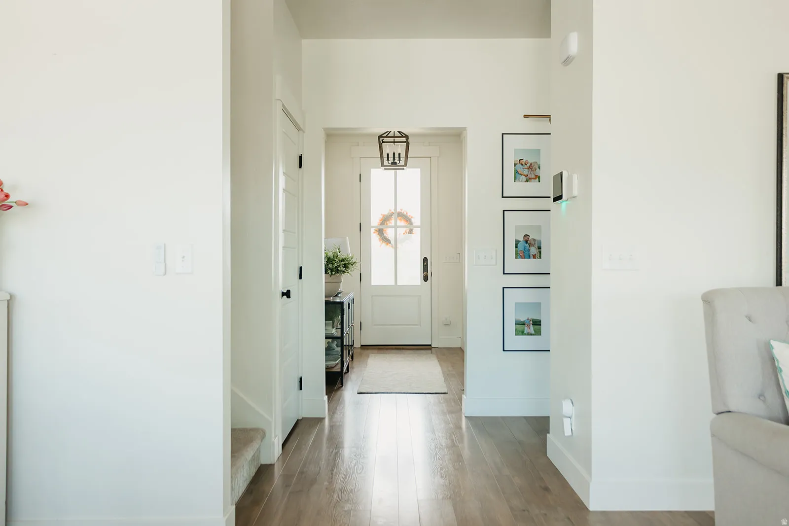 Entryway featuring wood-finish flooring, white walls, and a front door with a transom window