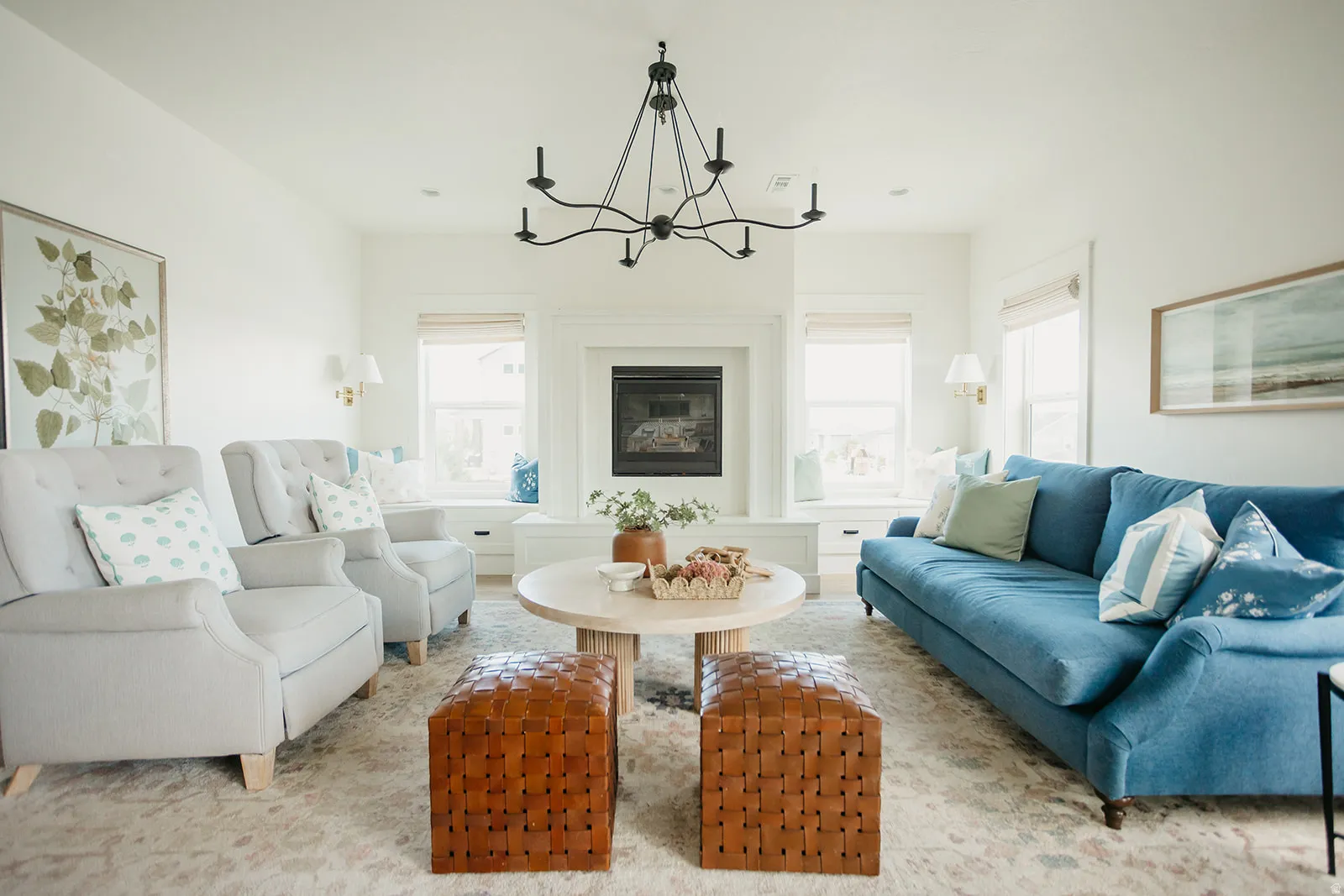 Central fireplace with a white mantel, flanked by built-in window seating, and a multi-arm chandelier
