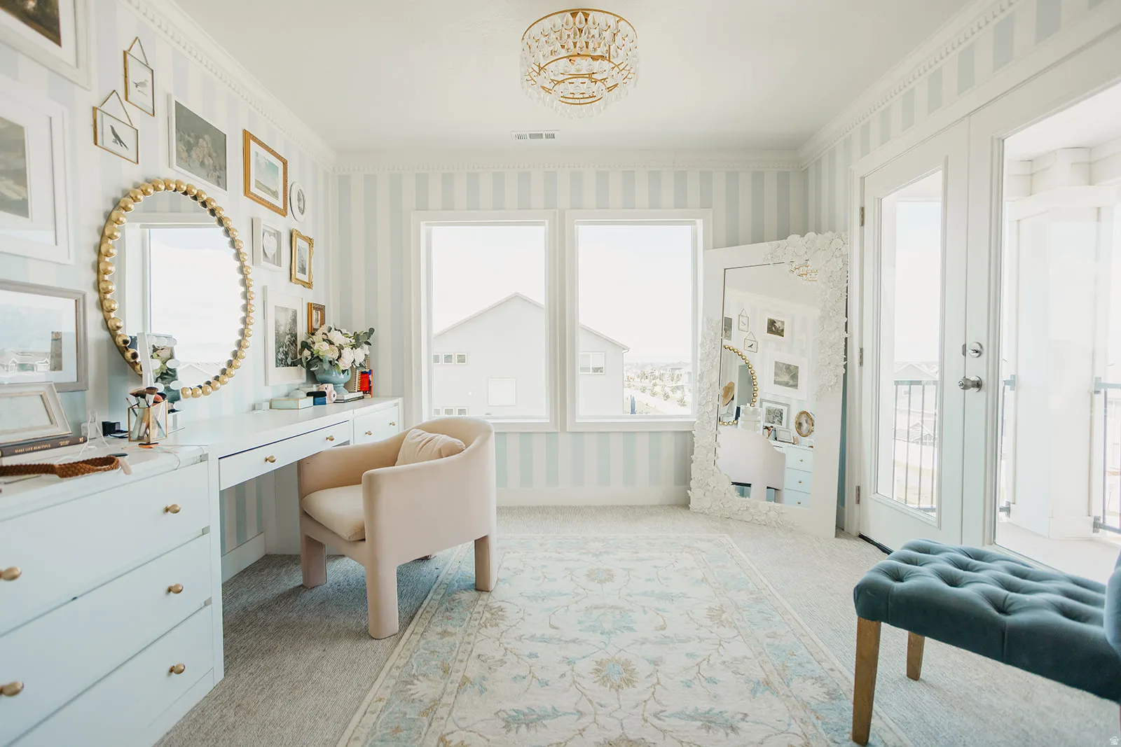 Dual windows with natural light, striped wall treatment, built-in desk with cabinetry, and direct exterior access
